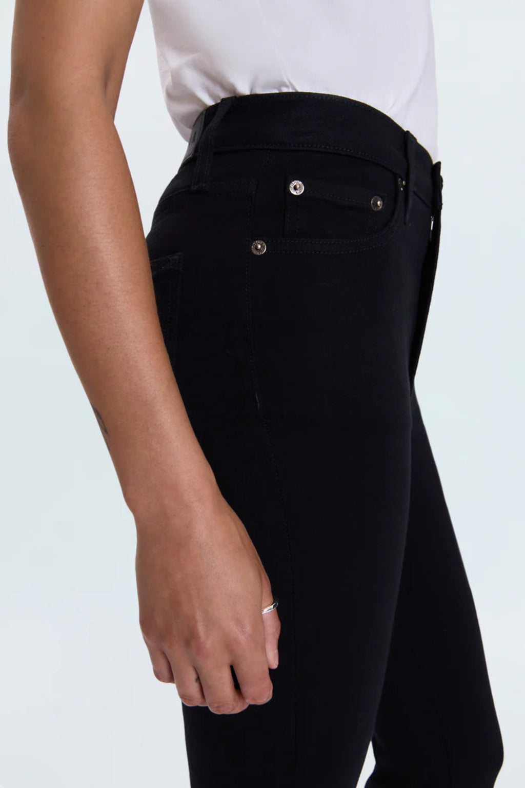Person wearing black pants with a white background.