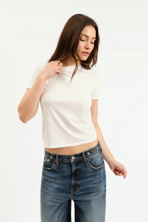 A woman wearing a white tshirt and denim jeans. 