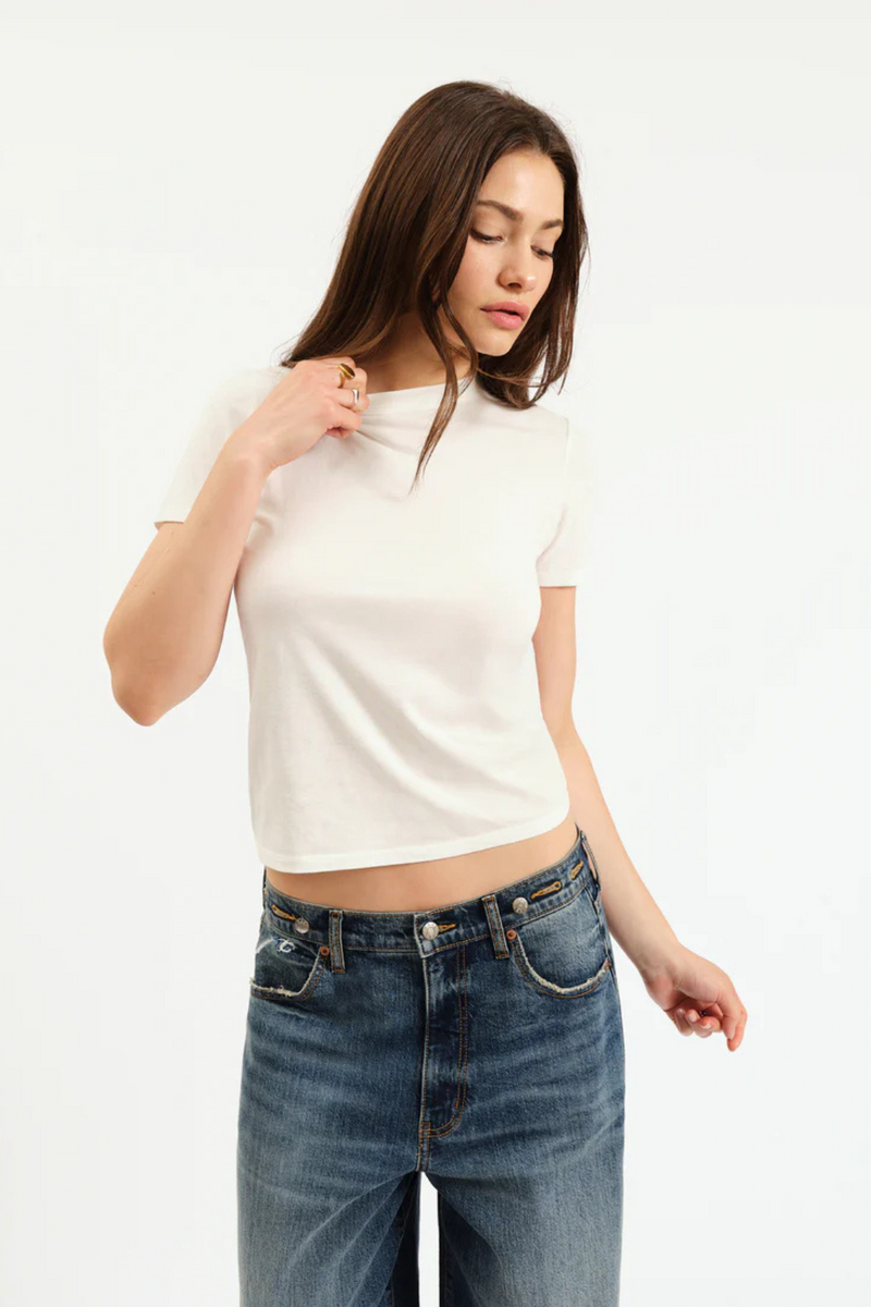 A woman wearing a white tshirt and denim jeans. 