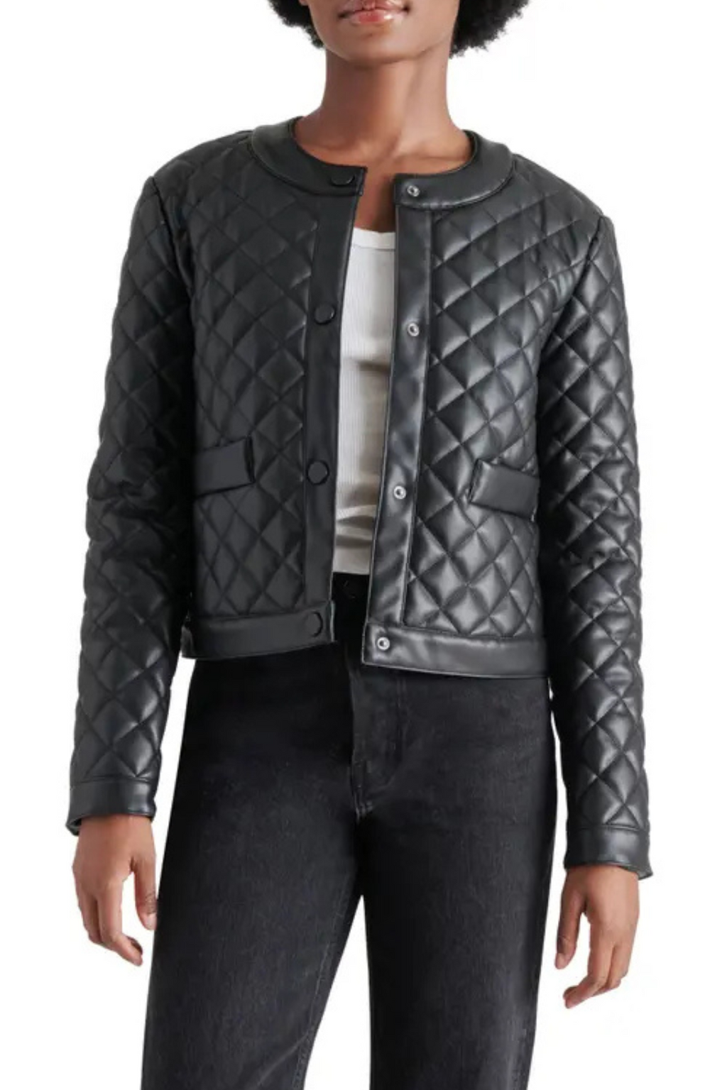 A woman wearing a quilted black jacket with black jeans.