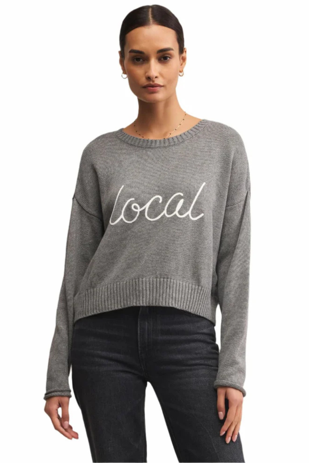 Woman wearing a gray sweater with 'local' text on a white background.