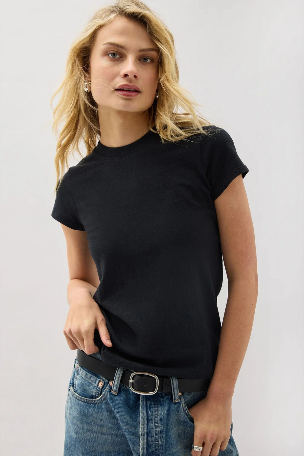 A woman wearing a black t-shirt and blue jeans.