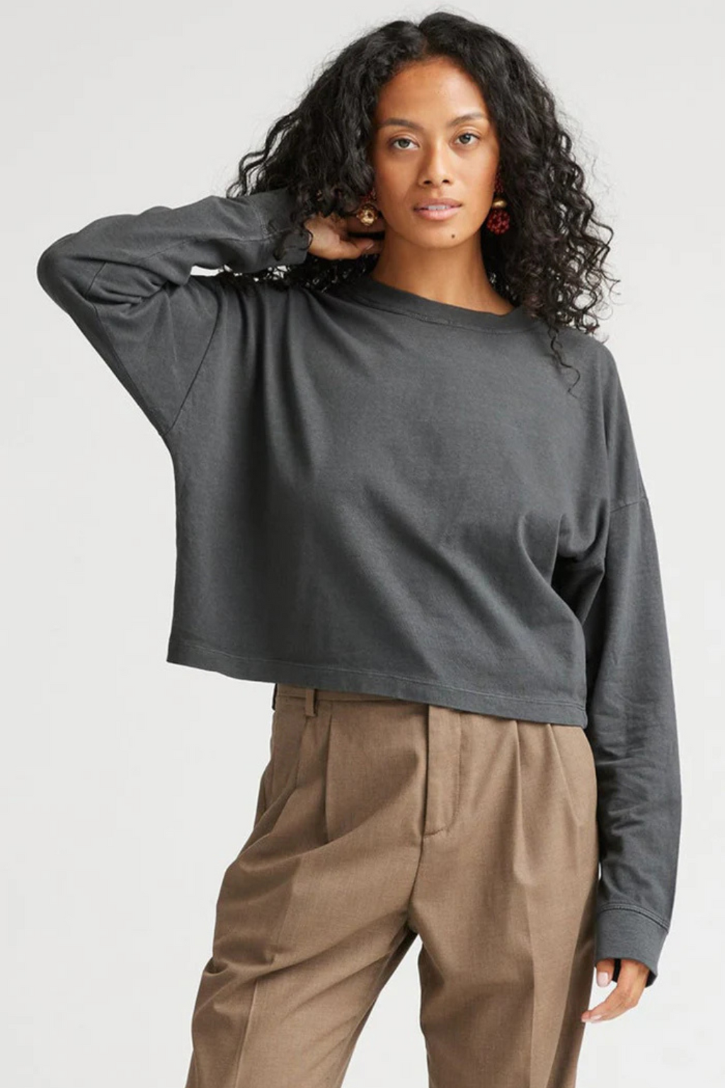 Woman wearing a long sleeve shirt and tan pants.