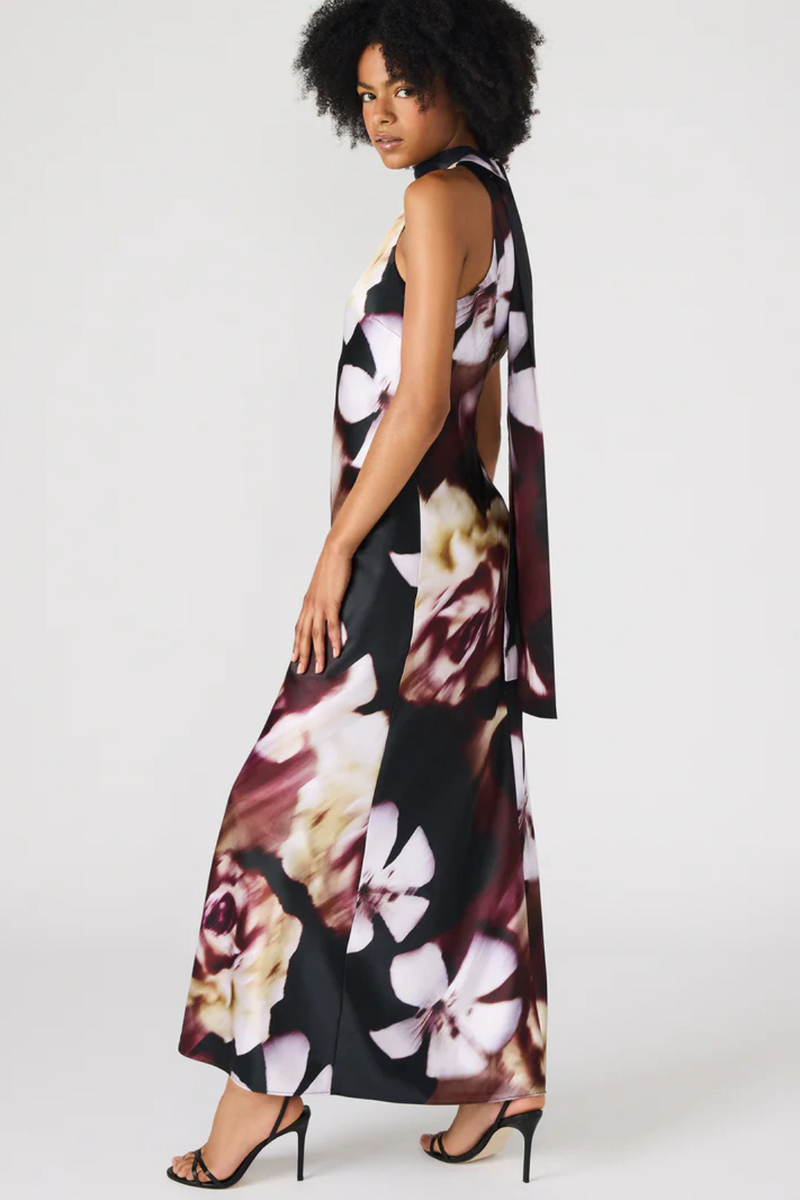 Woman wearing a floral dress on a white background.