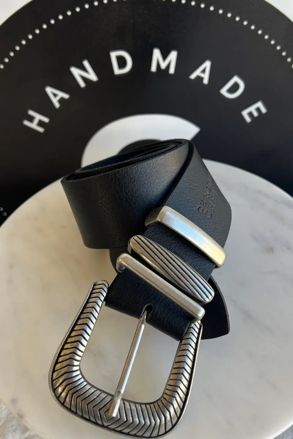 A close up shot of a black and silver buckle belt.