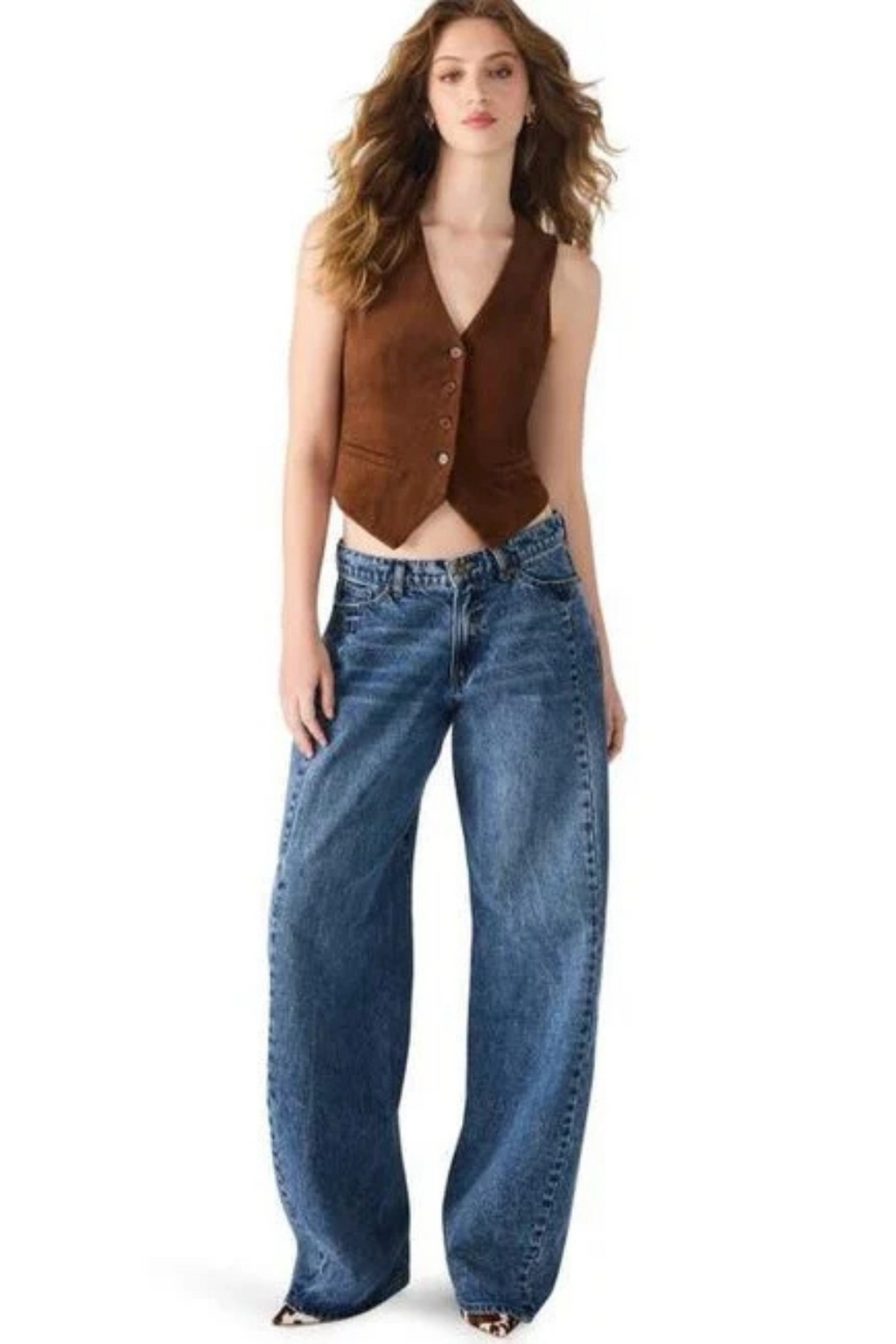 Woman wearing a brown vest and blue jeans on a white background.
