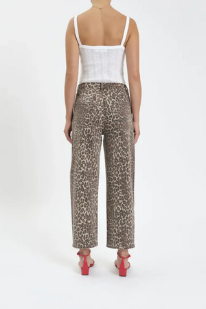 The back view of a woman wearing a white tank top, leopard barrel jeans and red heels. 