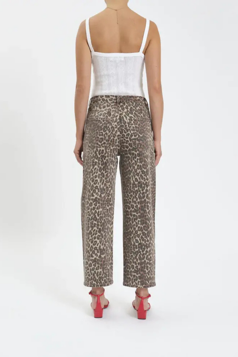 The back view of a woman wearing a white tank top, leopard barrel jeans and red heels. 