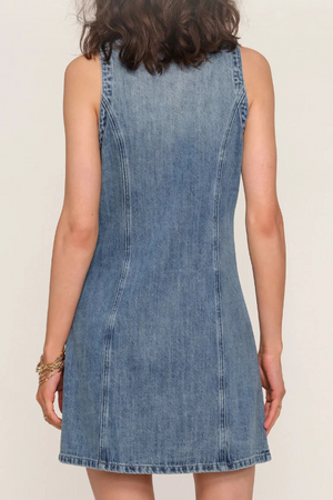 Denim dress back view worn by a woman on a plain background.