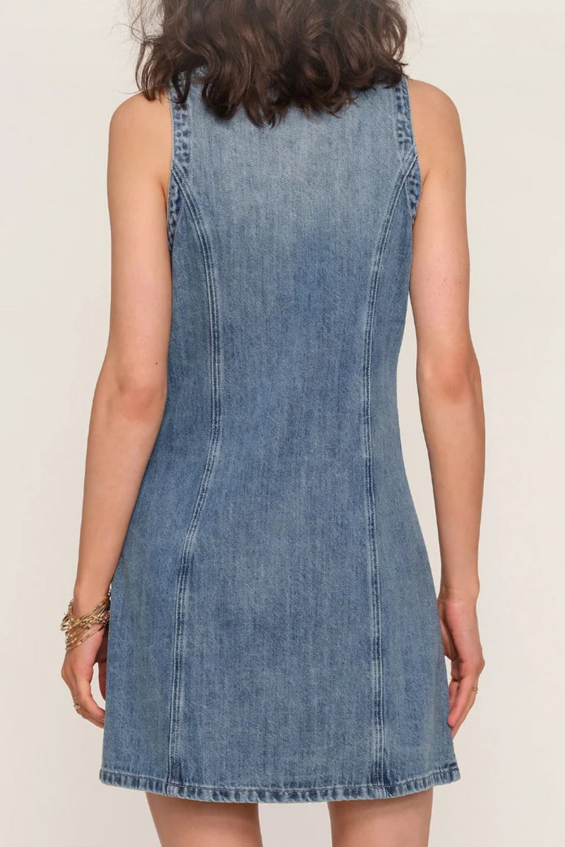 Denim dress back view worn by a woman on a plain background.