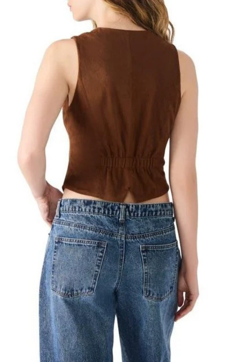 Person wearing a brown sleeveless top and blue jeans on a white background.