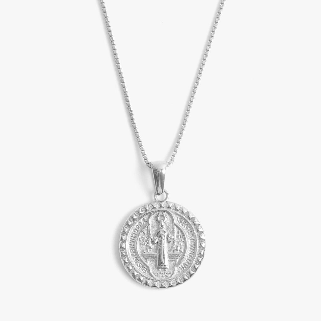 A front close view of a St. Benedict necklace in silver.