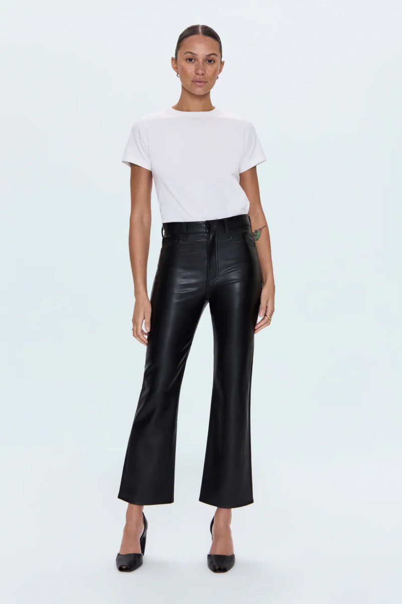 Person wearing a white t-shirt and black leather pants on a light blue background.