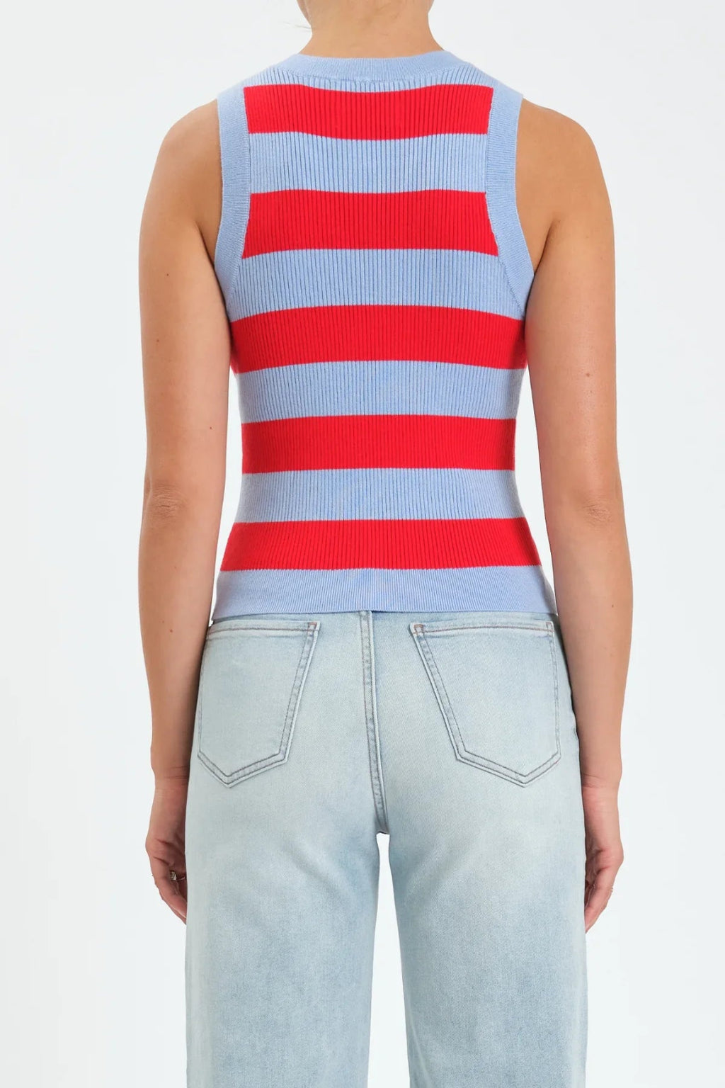 Back view of a woman wearing a red and light blue stripe tank with light denim jeans. 