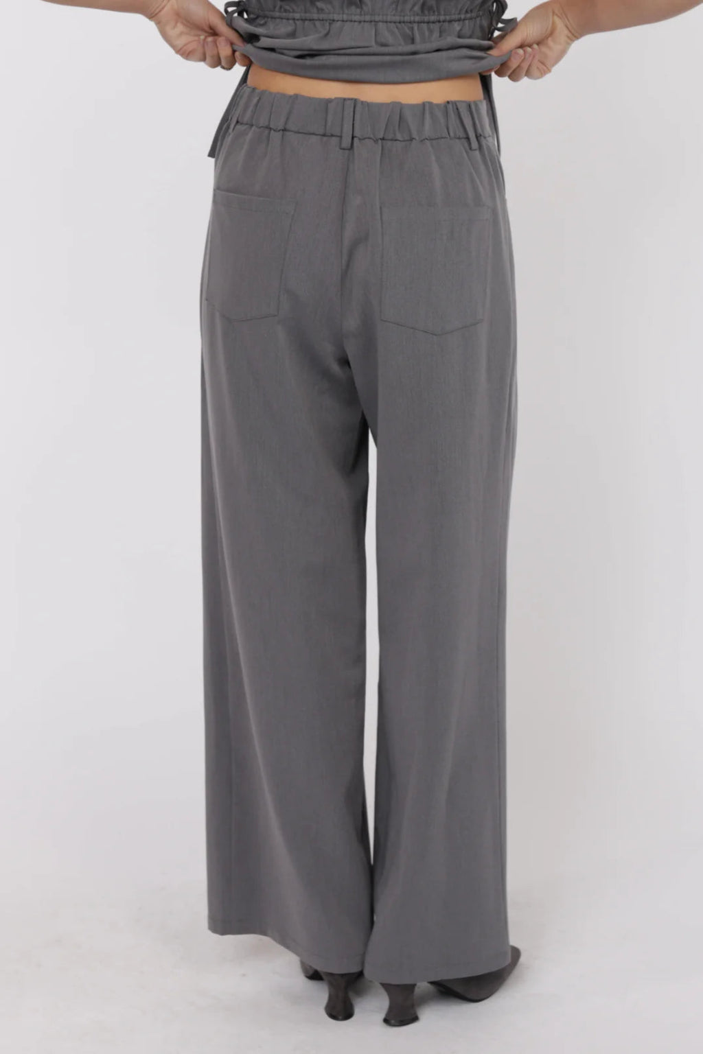 Gray wide-leg pants worn by a person on a white background.