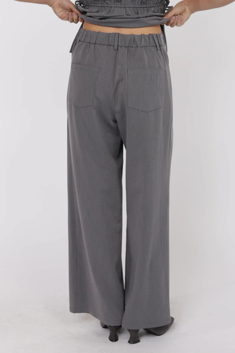 Gray wide-leg pants worn by a person on a white background.