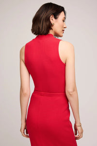Woman wearing a red dress against a plain background.