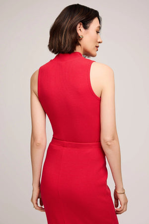 Woman wearing a red dress against a plain background.