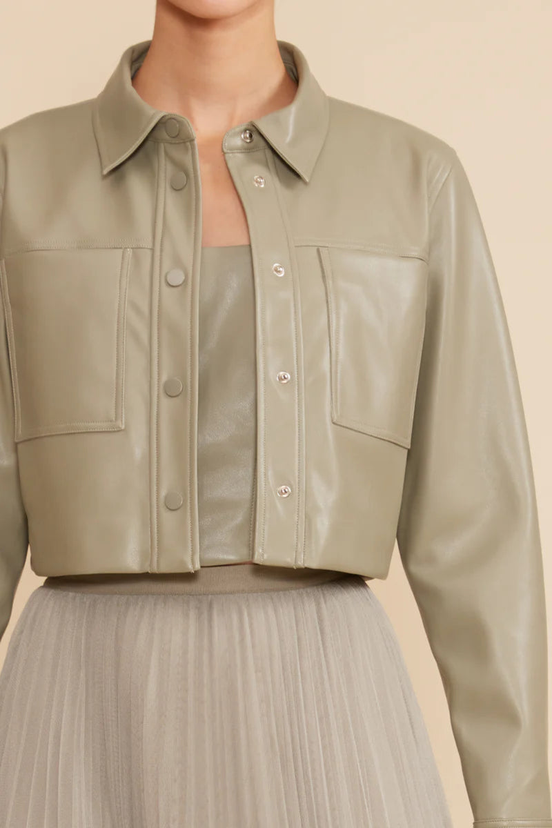 A woman wearing a Lucy Paris cropped jacket with a skirt.