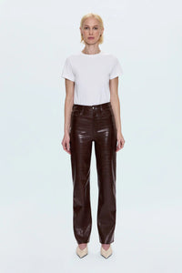 Woman wearing a white shirt with brown croc pants and cream heels. 