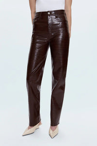 Brown leather pants worn by a person on a white background.