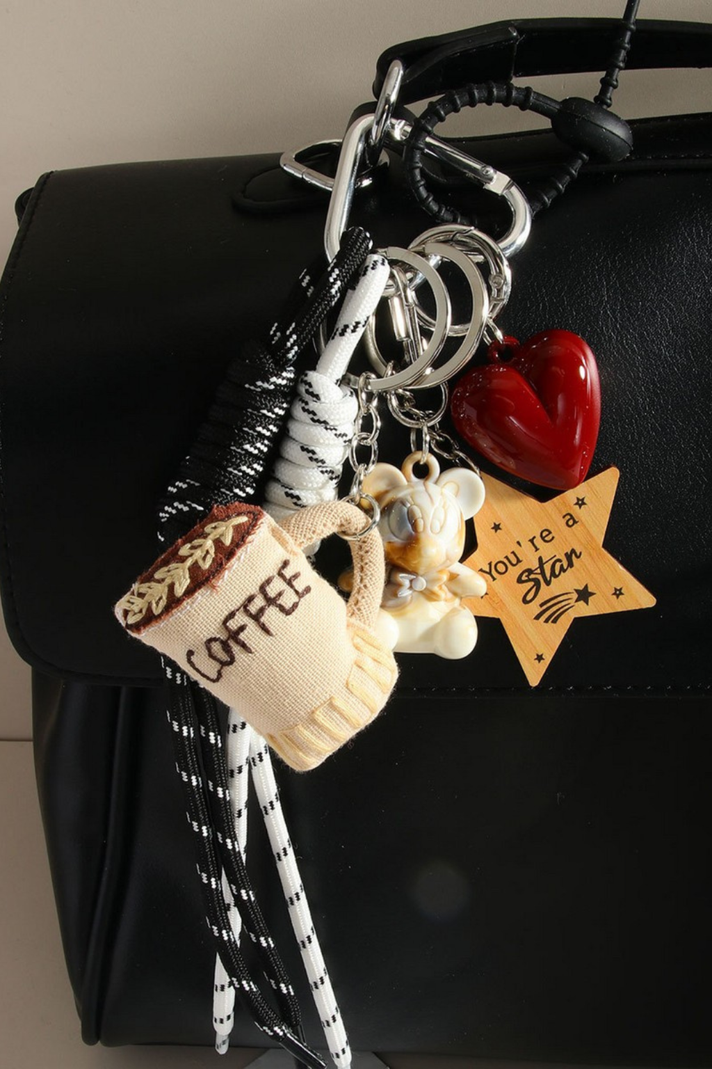 Keychain with various charms on a black bag.