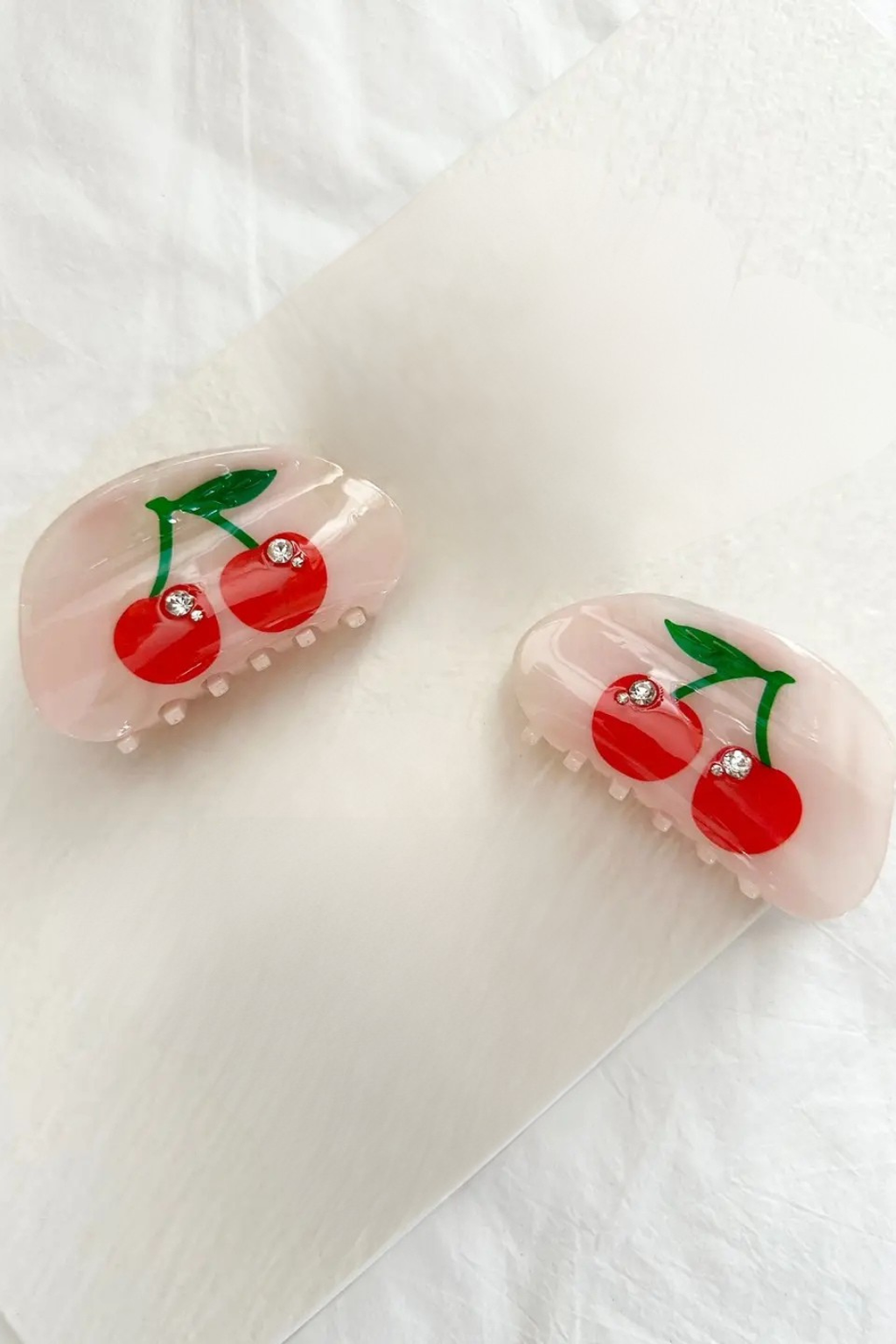 Hair clips with cherry design on a white background.