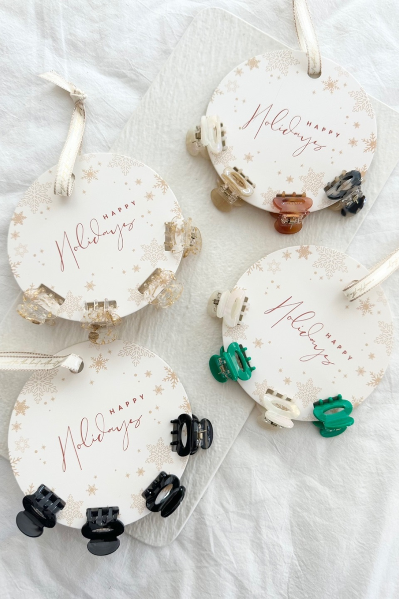 Mini hair clips on a circle label.