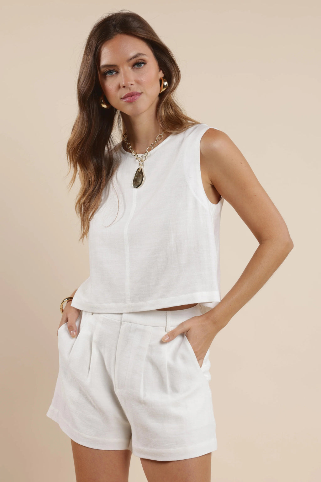A front view of a girl wearing a white tank top with matching shorts.