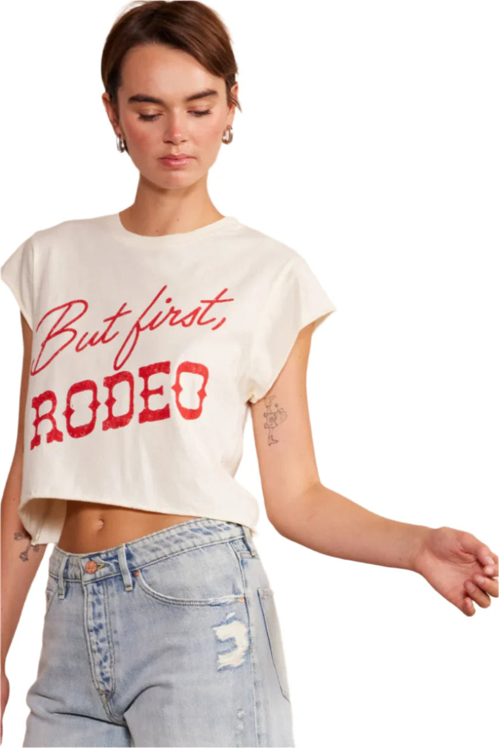 A closer view of a woman wearing a white shirt with red lettering, and denim shorts.