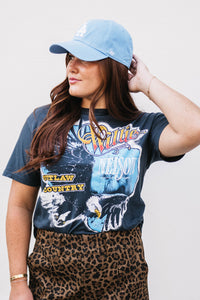 Woman wearing a graphic t-shirt and leopard print skirt with a plain background