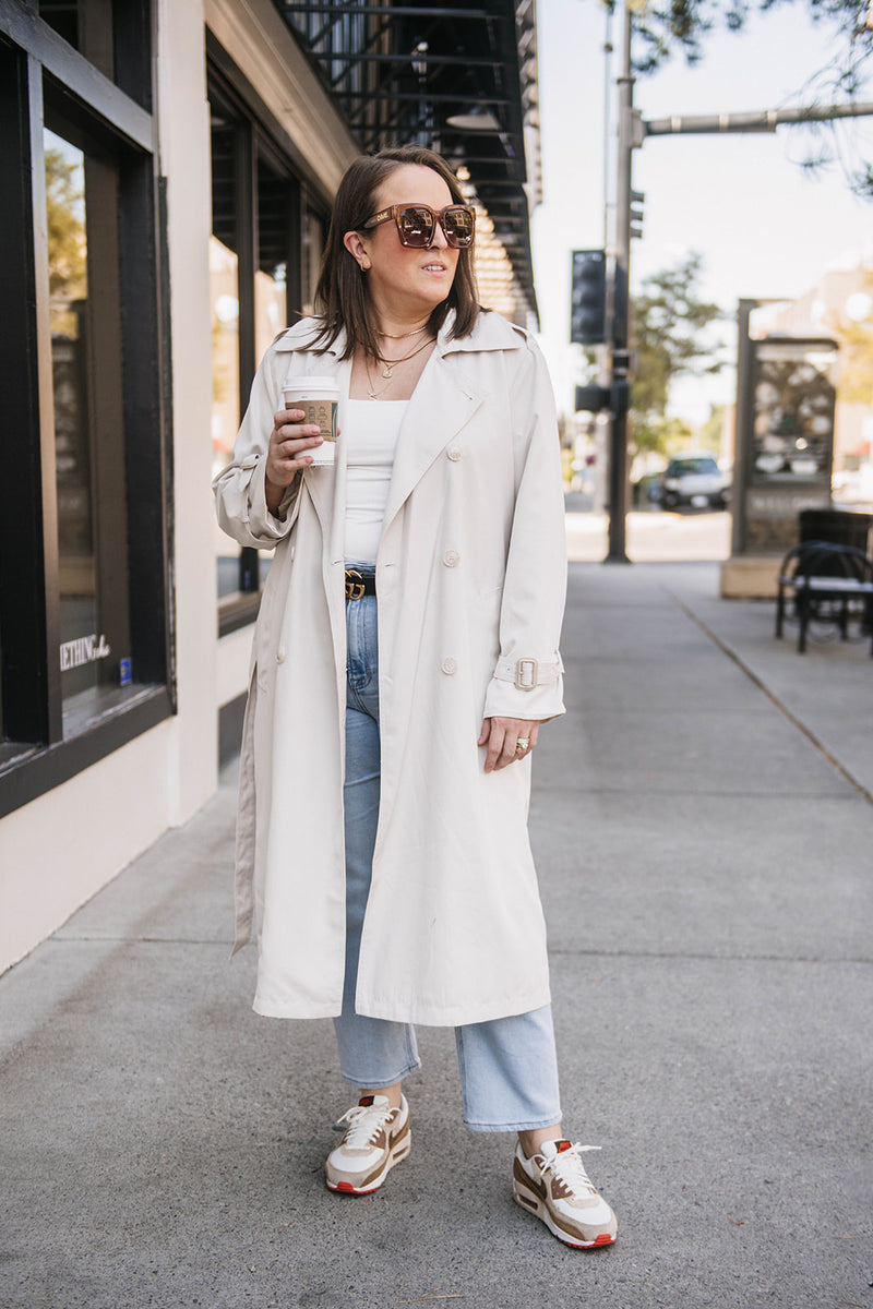 Woman wearing a cream trench coat while shopping in downtown Billings Montana