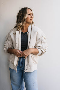 Woman looking to her left wearing a white bomber jacket | Women's Outerwear in Billings Montana