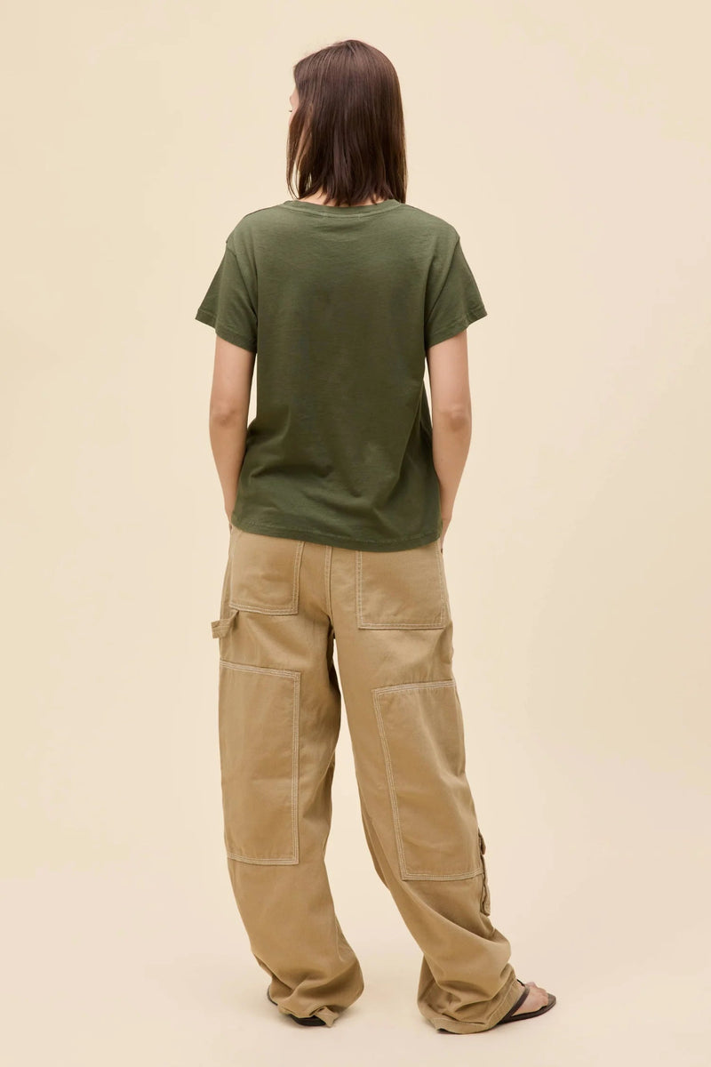 A back view of a girl wearing a Morgan Wallen graphic tee with tan pant and black sandals.