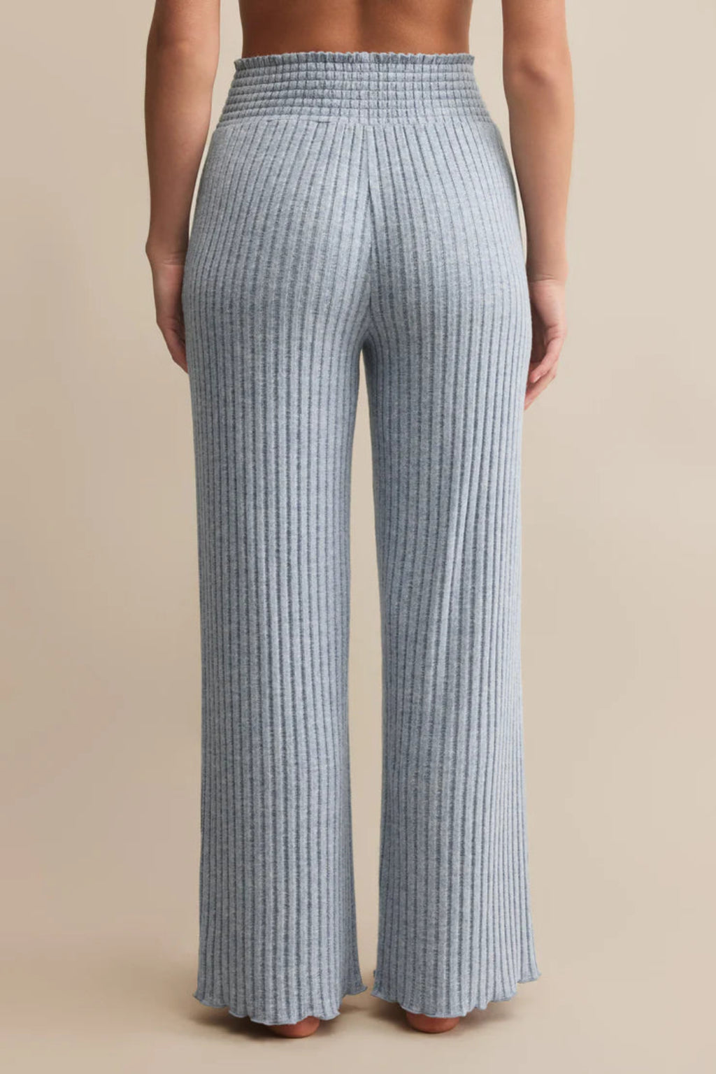 Blue checkered pants worn by a person on a beige background.