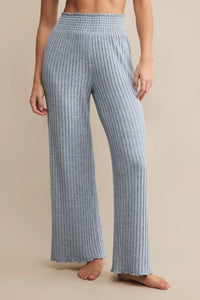 Person wearing blue checkered pants on a beige background.