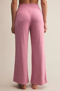 Pink wide-leg pants worn by a person on a beige background.