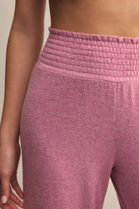 Close-up of pink textured pants on a neutral background.