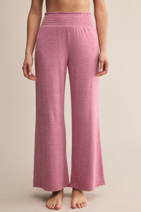 Pink wide-leg pants worn by a person on a beige background.