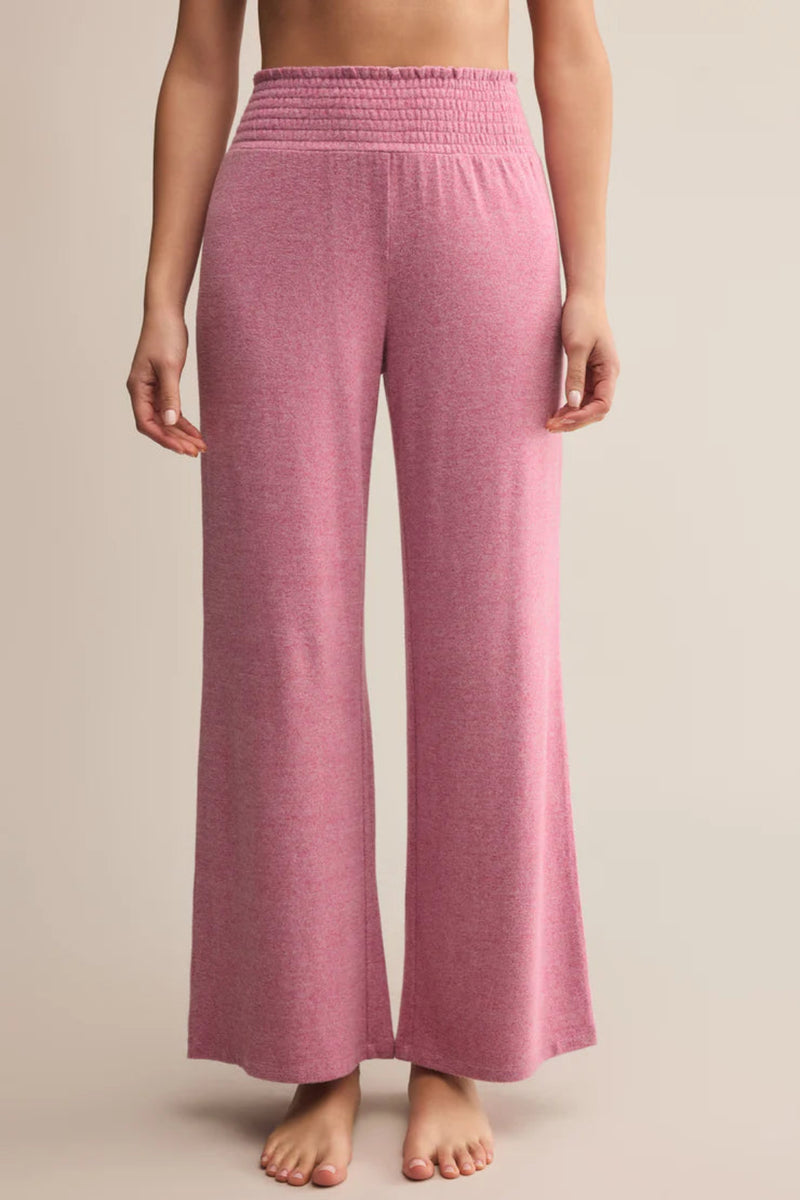 Pink wide-leg pants worn by a person on a beige background.