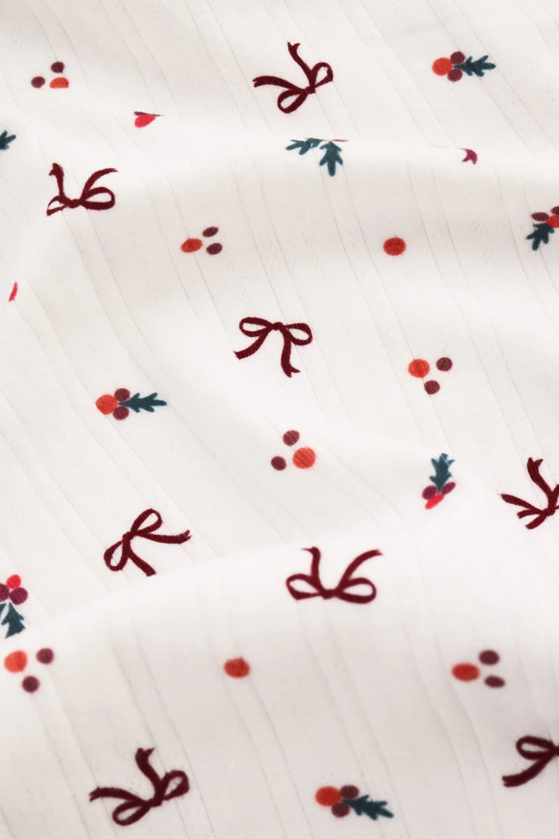 White fabric with red bows and berries pattern.