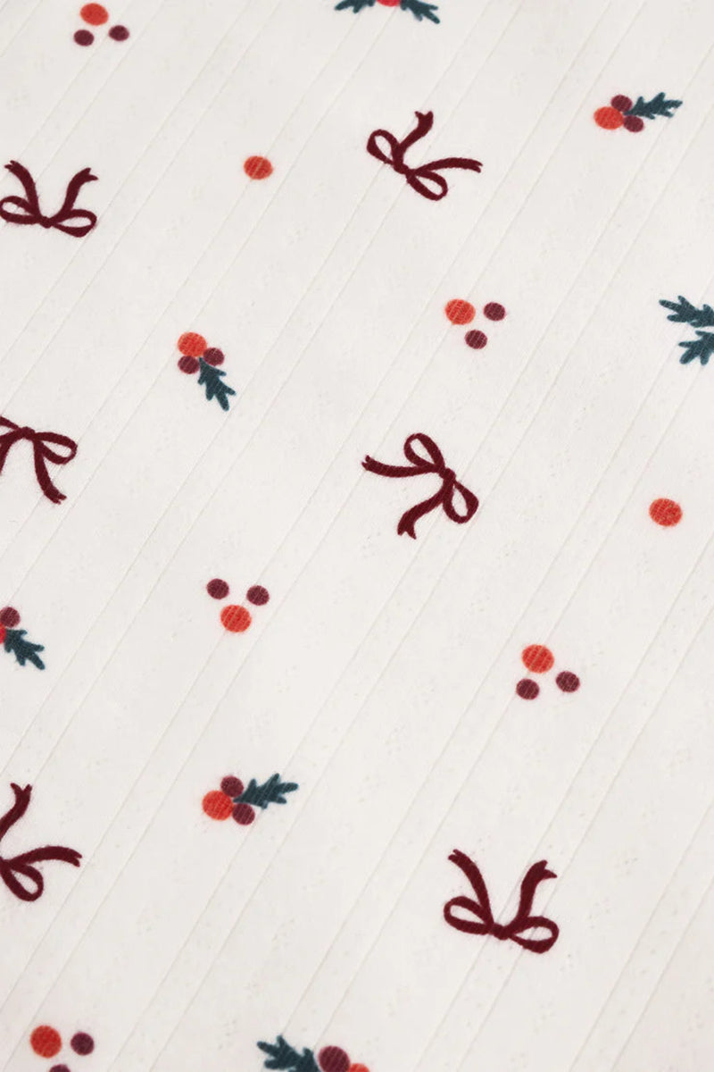 Pattern of red bows and berries on a white background.
