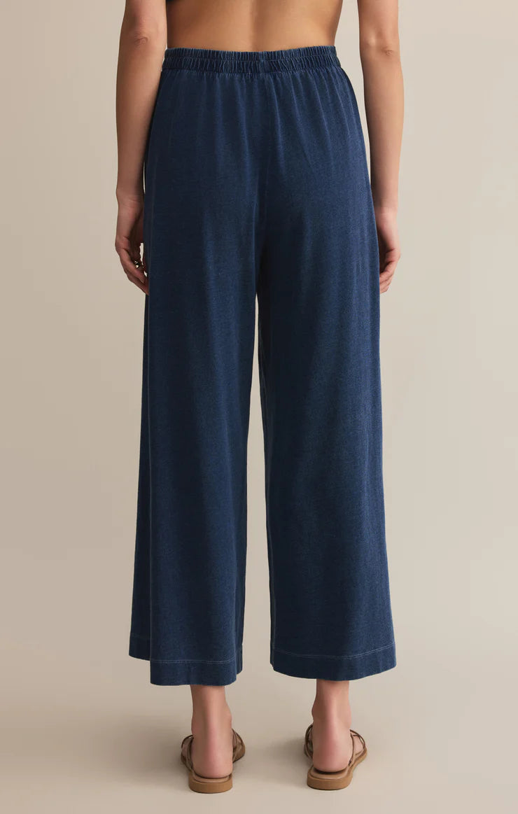Navy blue wide-leg pants worn by a person on a beige background.