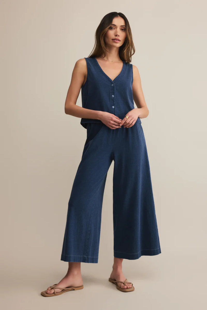 Woman wearing a blue matching set on a beige background.