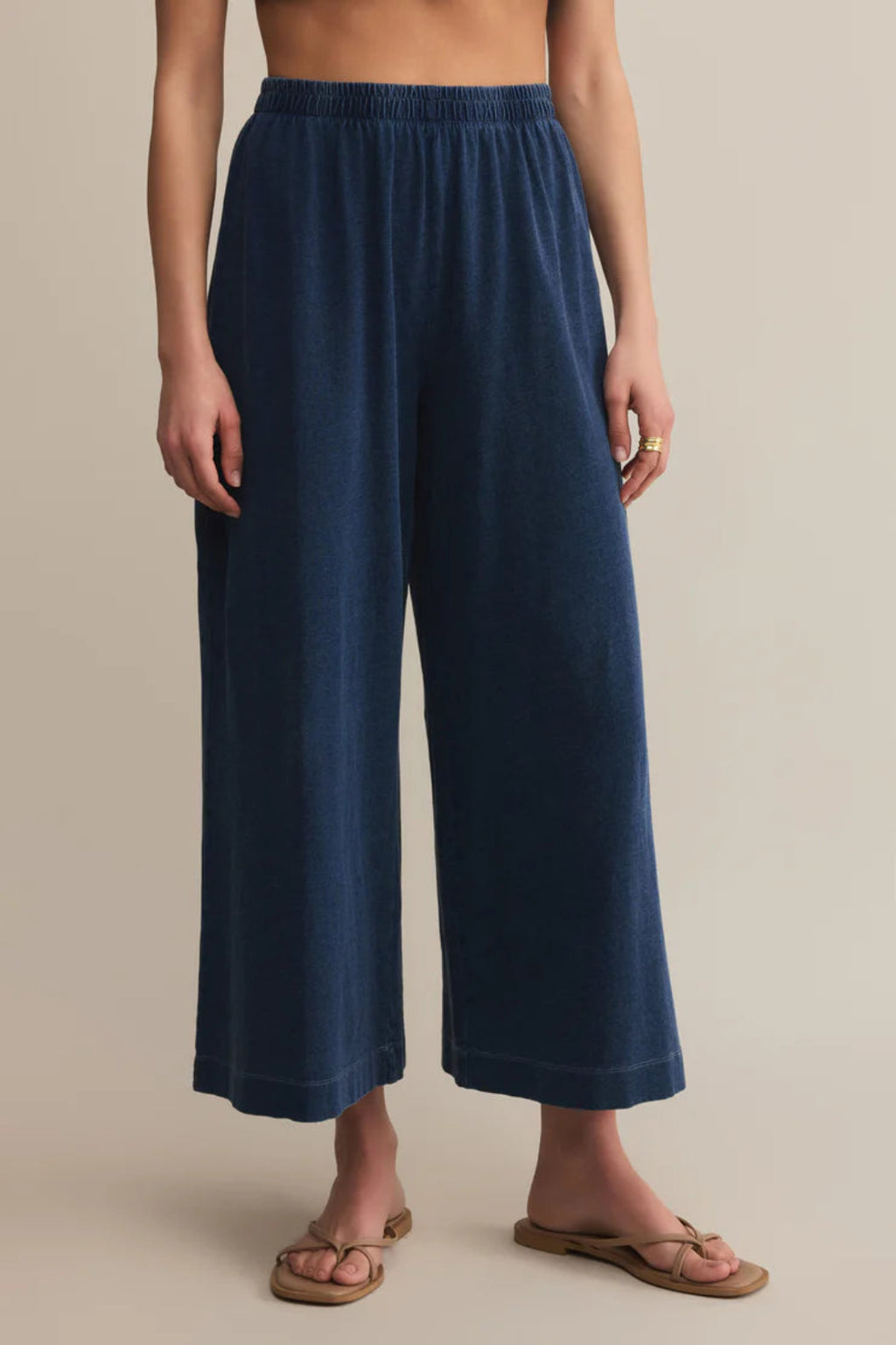 Navy blue wide-leg pants worn by a person on a beige background.