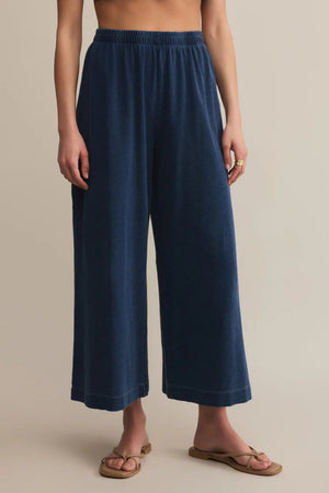 Navy blue wide-leg pants worn by a person on a beige background.