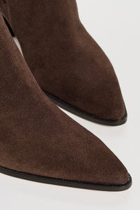 Brown suede pointed-toe boots on a white background.