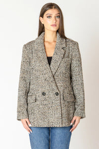 Woman wearing a tweed blazer and jeans.