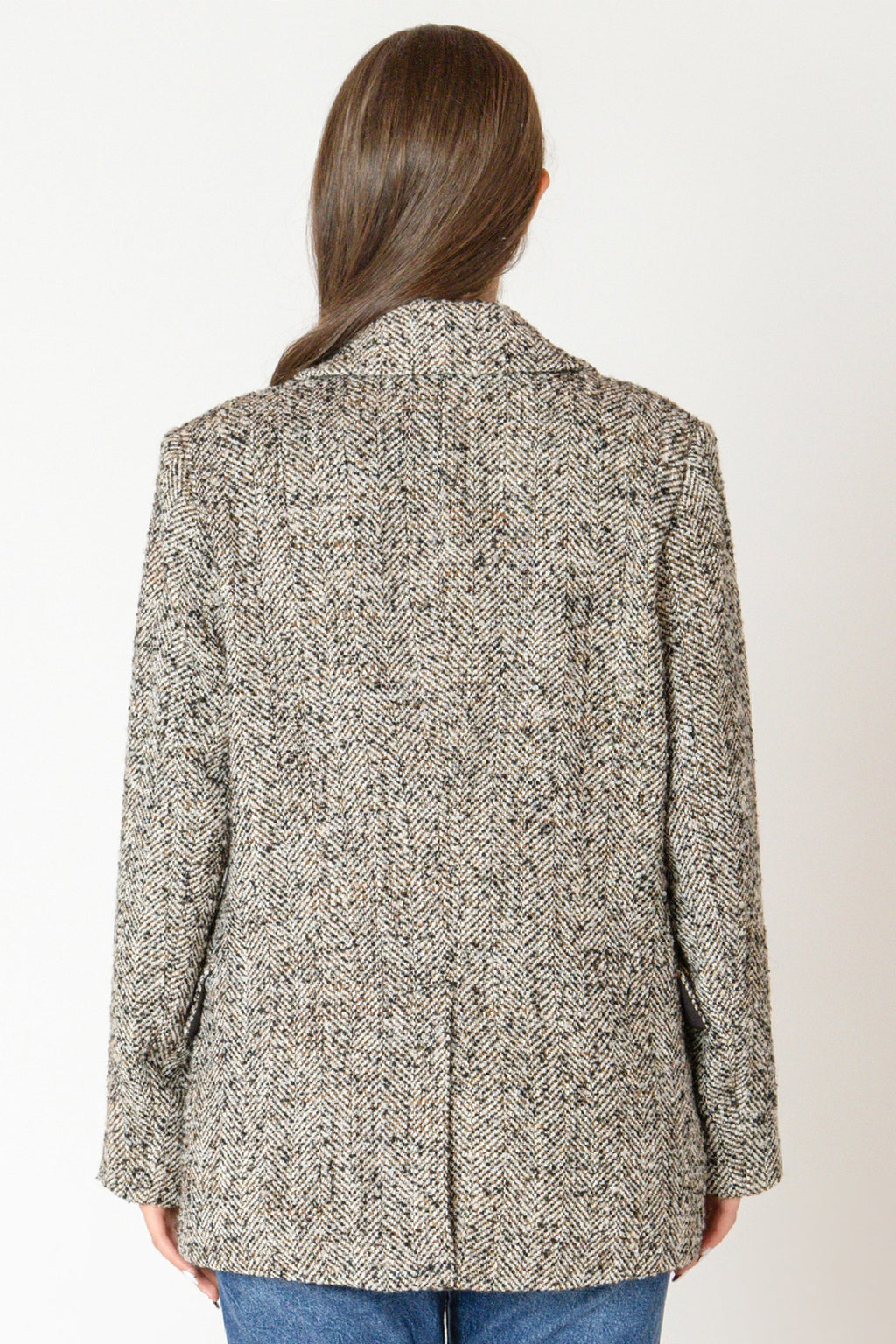 Back view of woman wearing a tweed blazer.
