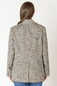 Back view of woman wearing a tweed blazer.